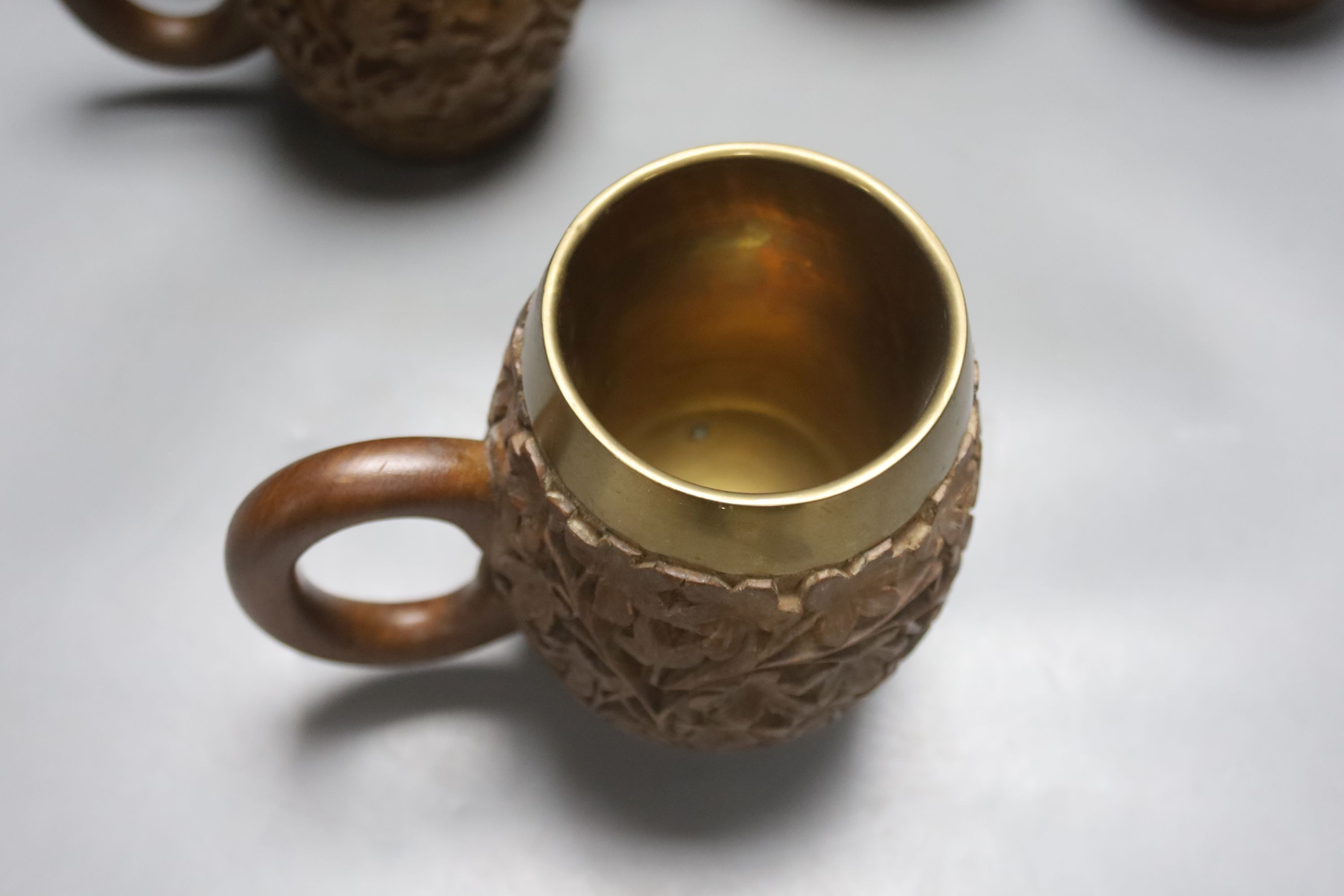 A set of six South Asian carved teak mugs 15.5cm